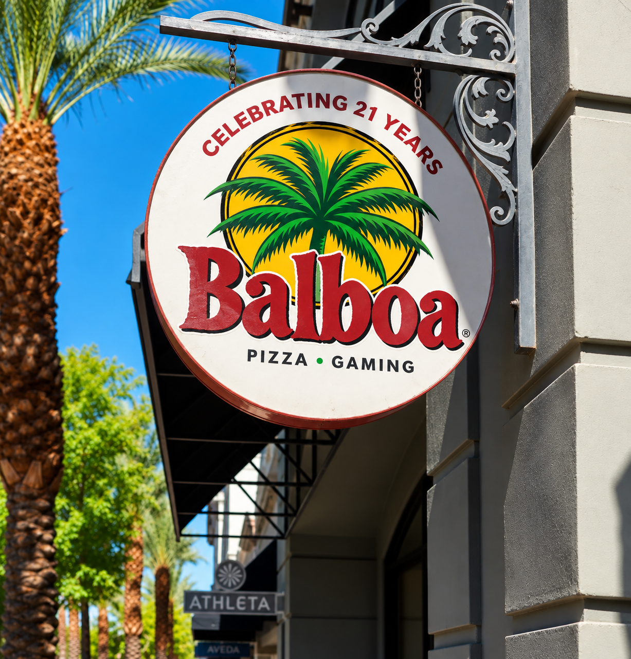 Balboa Pizza Company sign celebrating 21 years with palm tree logo hanging outside the restaurant
